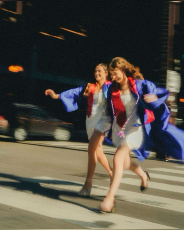 Graduates running across city street