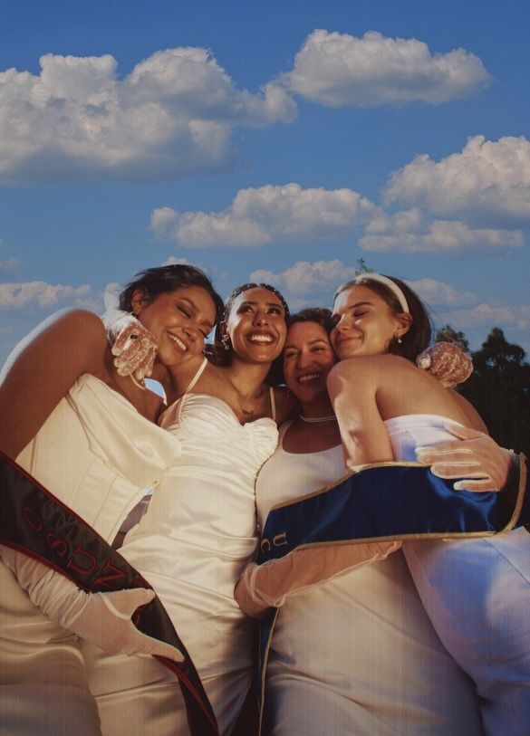 Graduates hugging under blue sky