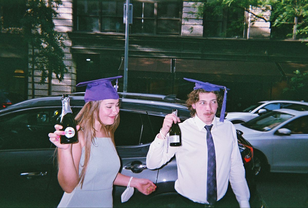 Two graduates celebrating on the street