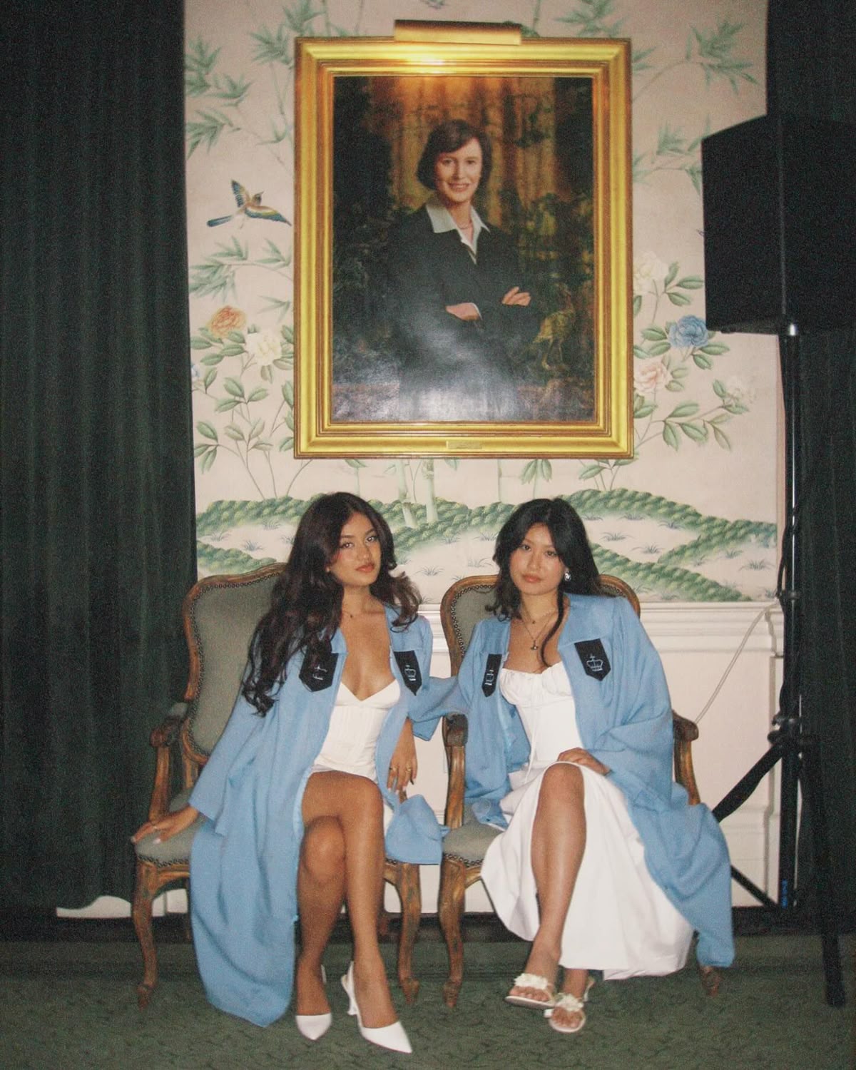 Two graduates seated in formal room